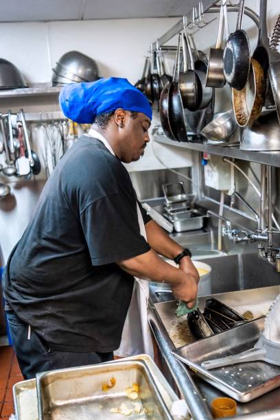 istock Afro Caribbean  dishwasher working at a restaurant kitchen 1365472674