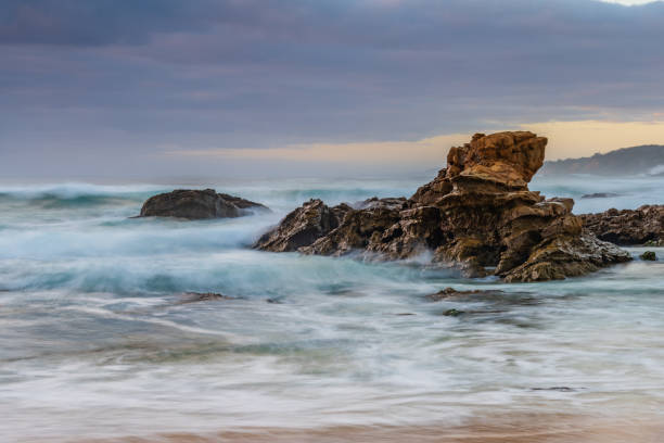 Rocks and waves - sunrise seascape at Bermagui stock photo