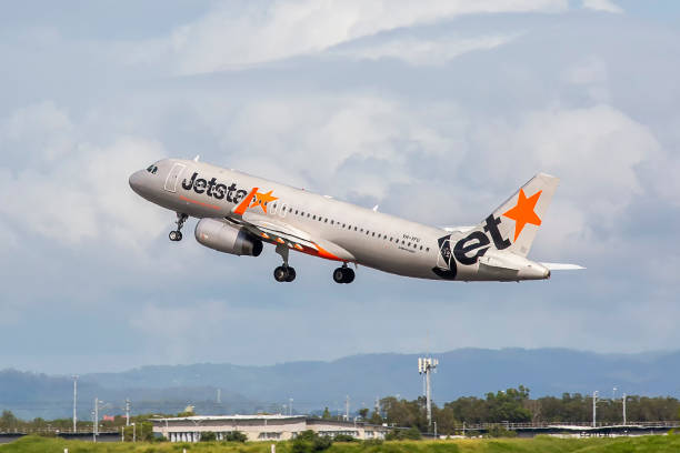 Jetstar Airbus A320 departing Brisbane International Airport This image is of a Jetstar Airbus A320 departing Brisbane International Airport runway 19L. Jetstar Airways Pty Ltd, operating as Jetstar, is an Australian low-cost airline (self-described as "value-based") headquartered in Melbourne. It is a wholly owned subsidiary of Qantas, created in response to the threat posed by airline Virgin Blue. Jetstar is part of Qantas' two brand strategy of having Qantas Airways for the premium full-service market and Jetstar for the low-cost market. Jetstar carries 8.5% of all passengers travelling in and out of Australia. airfoil photos stock pictures, royalty-free photos & images