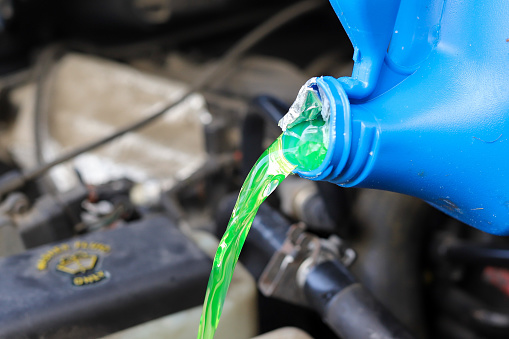 Close up of antifreeze being poured into a car reservoir