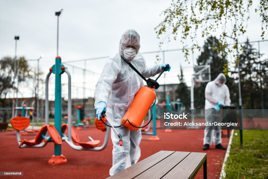 Outdoor Gym Sanitizing By Modern Healthcare Workers Protection Stock Photo
