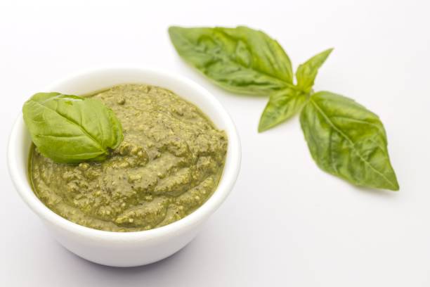 istock Homemade pesto and basil on white. 1365498590