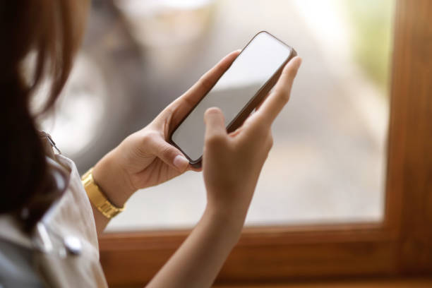 istock Female using smartphone at cafe, smartphone blank screen mockup. 1365499203