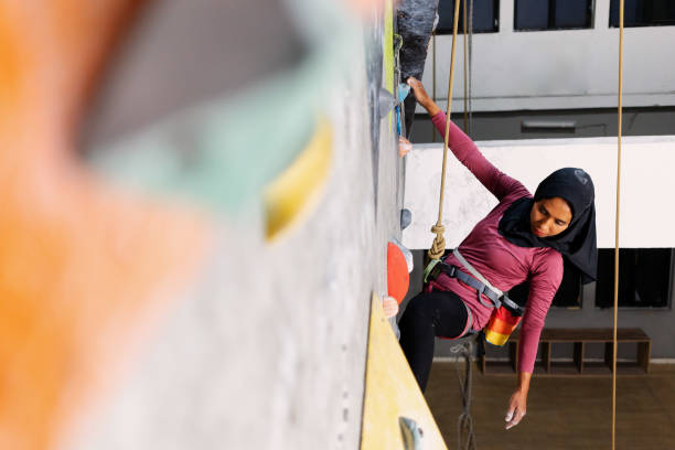 Indonesian Muslim Rock Climber Athlete Climbing Indoor Gym stock photo