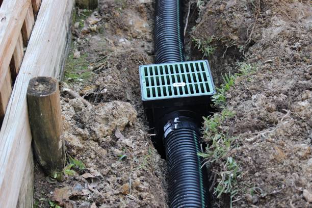 Building an Underground French Drain System after Digging the trench system to keep water away from home's foundation. Drainage ditch. Laying a drainage pipe using rain drainage sewage pipe and box. Earthwork. drainage photos stock pictures, royalty-free photos & images