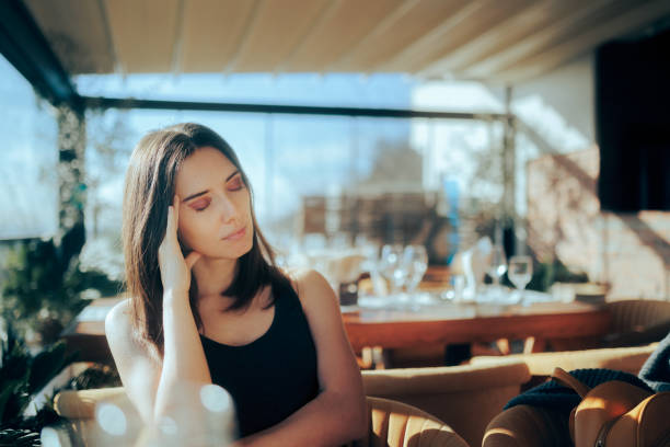 istock Woman Suffering a Headache while Waiting in a Restaurant 1365505879