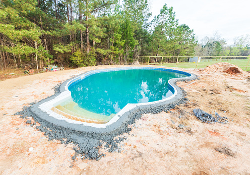 New swimming pool being installed in a back yard