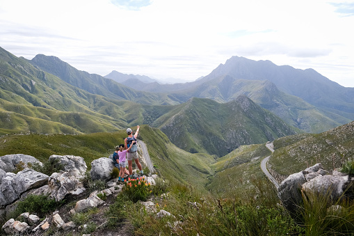 Fit woman enjoys an outdoor adventure with her two children. They are hiking above The Outeniqua Pass, connecting the coastal town of George with Oudtshoorn and the Little Karoo