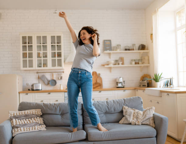 istock woman jumping on the sofa 1365513855