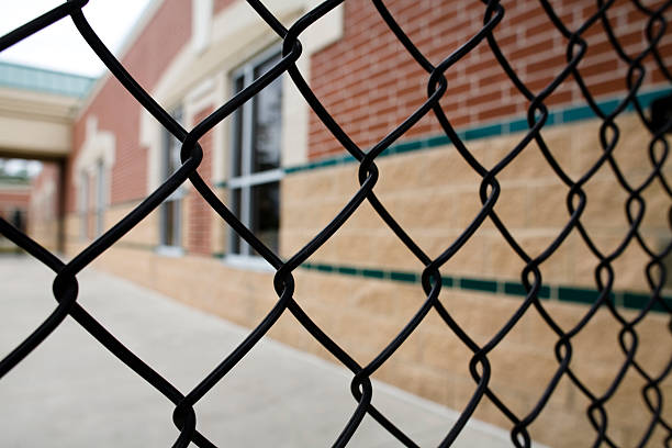 Chain link fence and school building. Education. Nobody.