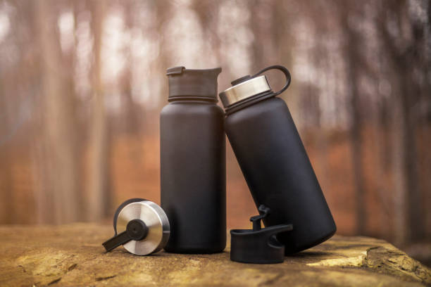 istock two black water bottles sitting on a rock in the woods 1365516407