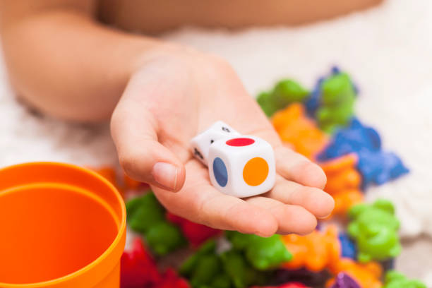 colored dice in a child's hand stock photo
