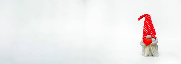 istock Leprechaun in a red hat with a red heart in his hands, isolated on a white background. Idea valentines day 1365524448