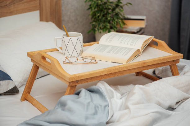 istock Cup of coffee and book on bed 1365532126