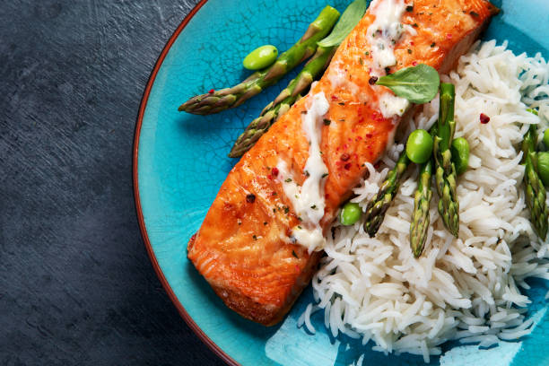 istock Baked salmon with rice and asparagus on gray background. 1365532781