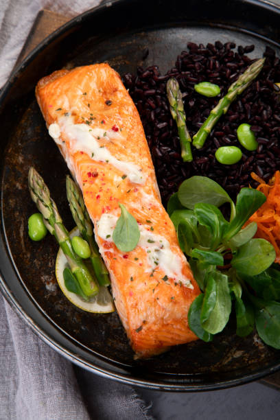 istock Baked salmon with asparagus and black rice. 1365532791