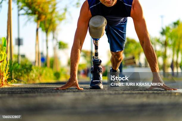 Disabled Athlete Man With Prosthetic Leg Starting To Run At The Beach On A Treadmill Outdoors At Sunset Stock Photo - Download Image Now