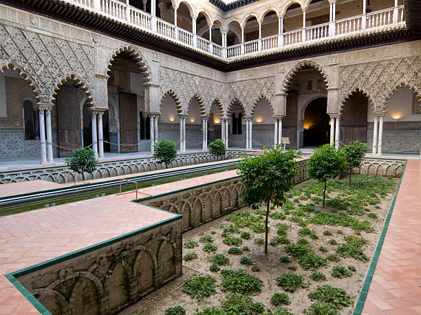 patio en el palacio de alcázar, naranjas - seville alcazar palace sevilla arch fotografías e imágenes de stock