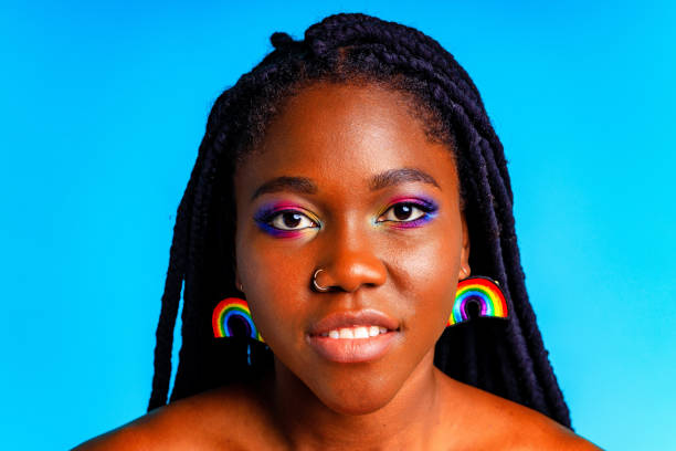 Female with rainbow make-up and long eyelashes in blue studio baclground