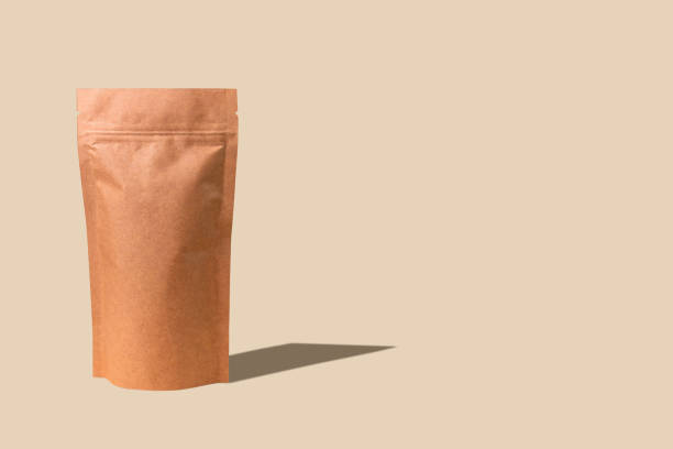 istock Pouch bag mockup neutral beige background monochrome. Merchandise packaging. Blank brown kraft paper pack demonstration. 1365535412