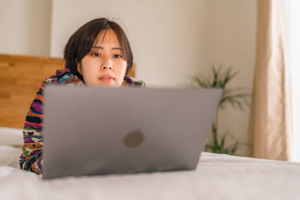 istock Young woman relaxing on bed in bedroom 1365536324