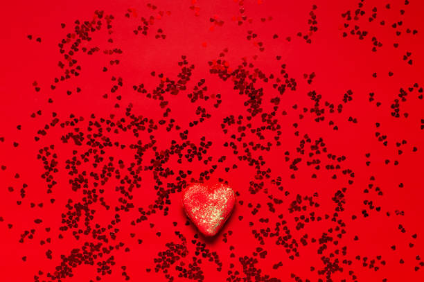 Heart Shaped Macaroon Cake and confetti on red background top view Flat lay. Creative composition for Valentine's Day, love concept, birthday present, mother day, holiday background. Love for sweets