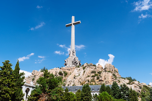San Lorenzo de El Escorial, Spain - August 29, 2021: The big cross of the Valle de Los Caidos or The Valley of the Fallen a monumental memorial