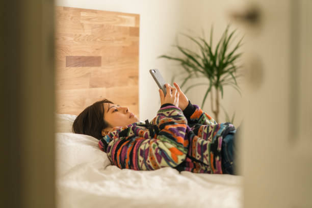 istock Young woman relaxing on bed in bedroom 1365539336