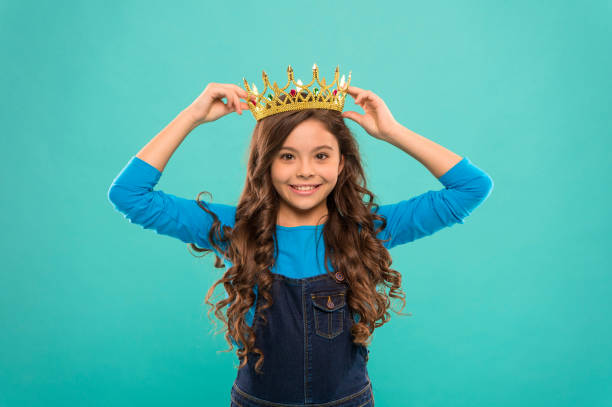 egoistisches kind lange lockige haare. luxus und erfolg. finden sie ihre motivation. kleines mädchen in königin krone. fühlt sich wie big boss. ein egoist zu sein. belohnung für echten champion. kleine prinzessin - princess crown tiara prom stock-fotos und bilder