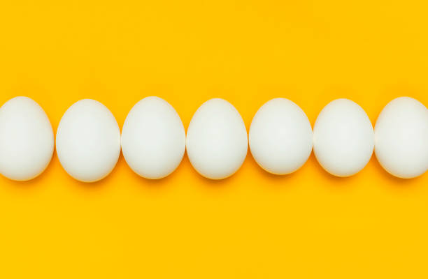 istock Creative food minimalistic background, Easter. White chicken eggs on yellow background top view flat lay copy space. Natural healthy food and organic farming concept. 1365539572