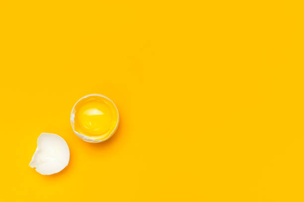istock White chicken eggs and one broken egg with yolk on yellow background top view flat lay copy space. Creative food minimalistic background, Easter. Natural healthy food and organic farming concept. 1365539584