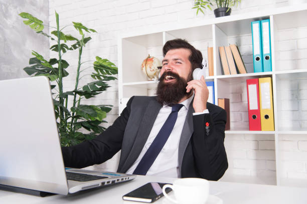 gestion d’entreprise en ligne. les détaillants utilisent un ordinateur portable et des écouteurs. commerce commercial. un homme barbu travaille dans un bureau d’affaires. communication d’entreprise. nouvelle technologie. commerce électronique. vid - audio engineer photos et images de collection