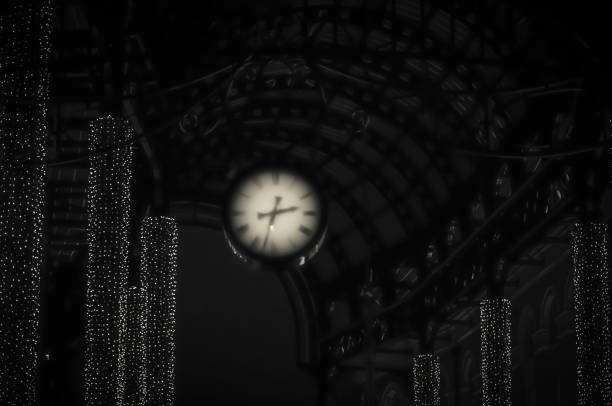 Abstract hanging clock and lighting under archway with old fashioned 1930s feel black and white
