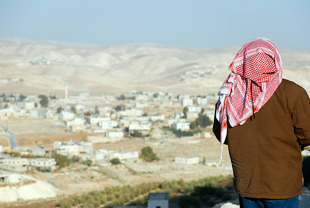 Palestinian man looking at West Bank landscape from the Herodian A Palestinian man looking down at his village from the Herodian, in the West Bank historical palestine photos stock pictures, royalty-free photos & images