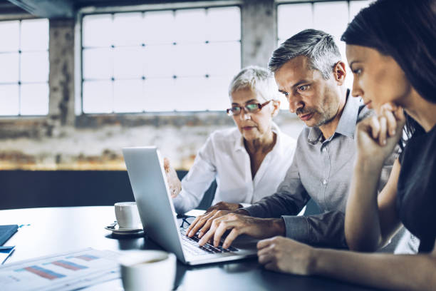 istock Business colleagues cooperating while working on laptop in the office. 1365541960