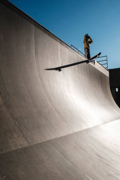 Skater dropping Young skater dropping on mega ramp with big shadow extreme skateboarding stock pictures, royalty-free photos & images