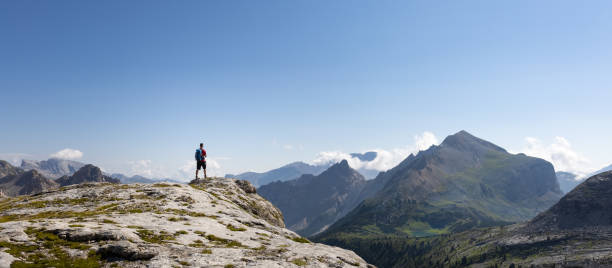 istock Hiker standing in a mountain panorama 1365542492