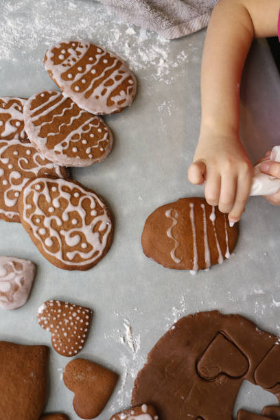 Girl decorates homemade gingerbread for Easter