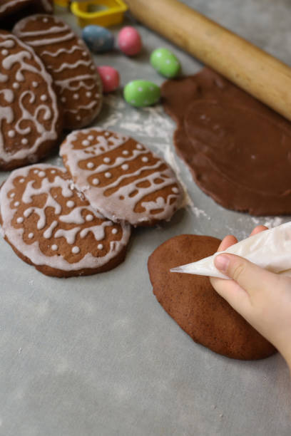 Girl decorates homemade gingerbread for Easter