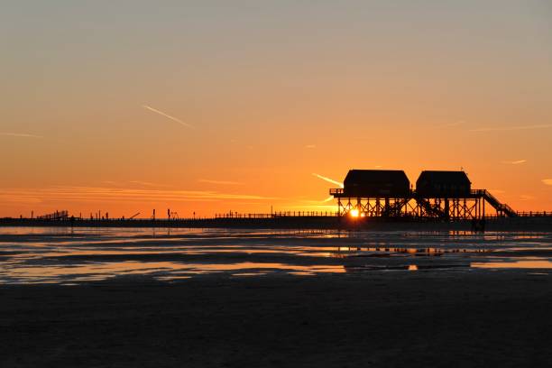 Sunset on the beach in December 2021 Beach scenery in Wadden Sea National Park in Sankt Peter-Ording, Schleswig-Holstein, known for its pile dwellings stilt house stock pictures, royalty-free photos & images