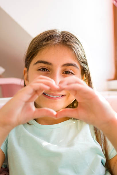 istock Beautiful girl making a heart-shaped figure 1365545010