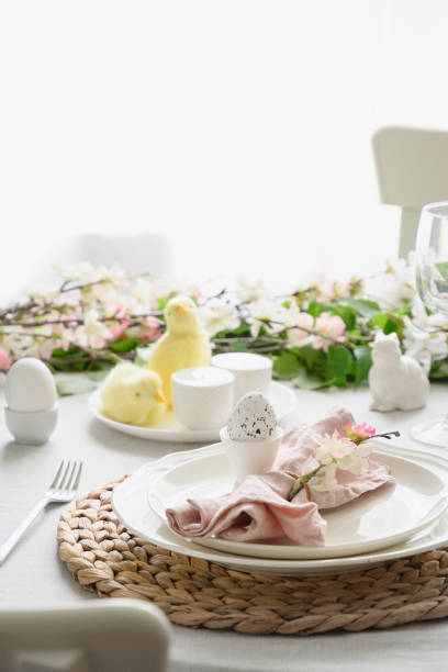 Easter table setting with yellow chick, fresh flowers and eggs. Close up.