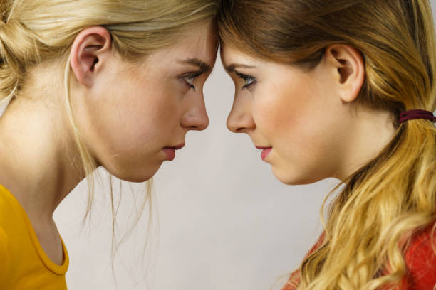 istock Two girls looking serious at each other. 1365548756