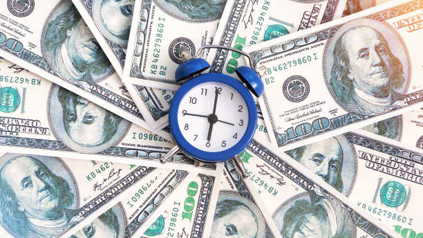 istock A layer of money with clock in the center 1365549708