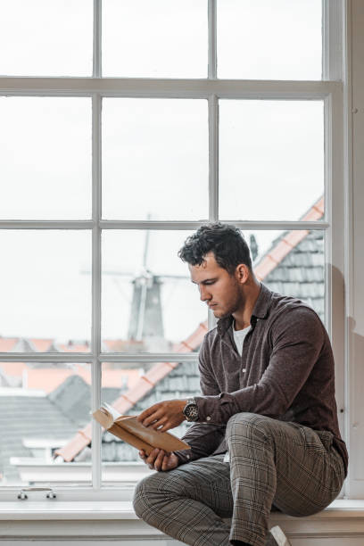 istock Handsome male student in a public library 1365549864