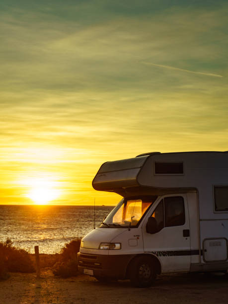 istock Camper car on beach at sunrise 1365550046