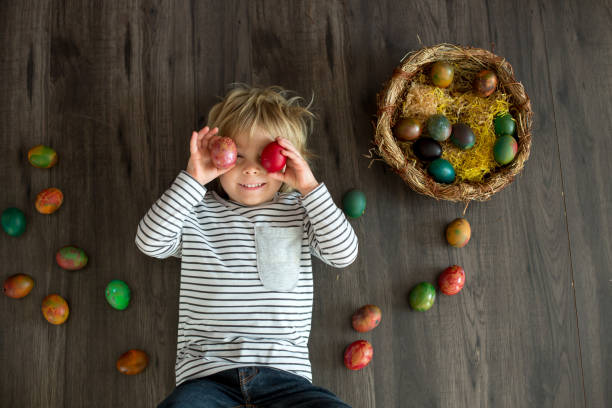 Sweet toddler child, cute boy playing with colorful easter eggs, studio shot