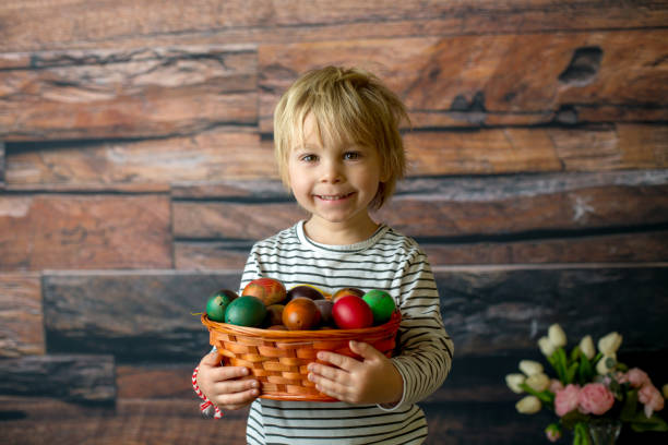Sweet toddler child, cute boy playing with colorful easter eggs, studio shot