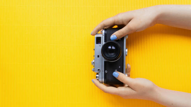 istock Female hands holding vintage photo camera 1365551246