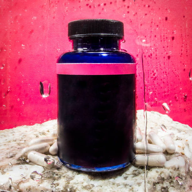 Medicine supplement pill bottle blank label on rock with pink background